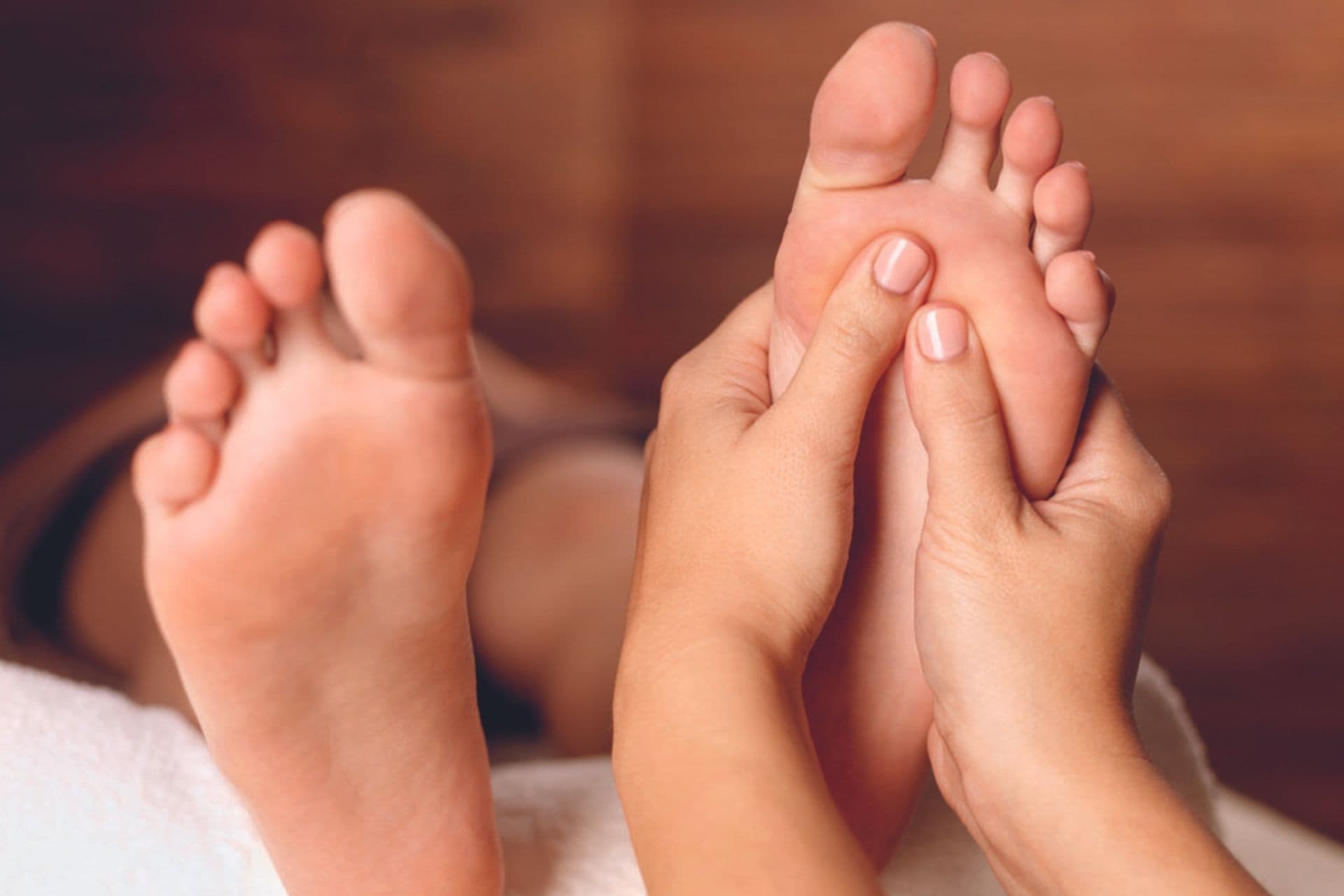 Foot reflexology, thumb pressure on a reflex point of the foot